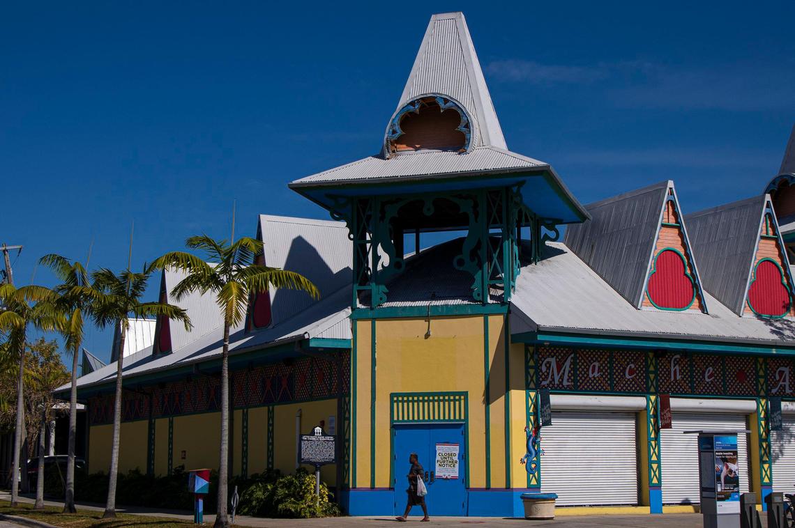 A pedestrian strolls past the shuttered Caribbean Marketplace in Little Haiti on Wednesday, April 1, 2020, during the coronavirus pandemic.