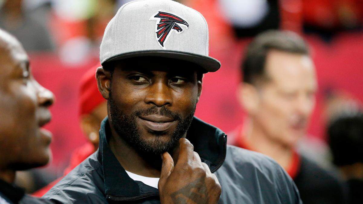 In this Jan. 1, 2017, file photo, former Atlanta Falcons quarterback Michael Vick stands on the sidelines before an NFL football game between the Falcons and the New Orleans Saints in Atlanta.