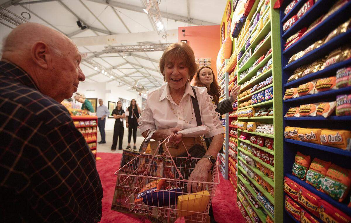 (Center) Dorothy Koreman and (L) her husband Neil Koreman shop art from "Sugar Rush" at ART MIAMI in MIami on Tuesday December 2nd., 2025.