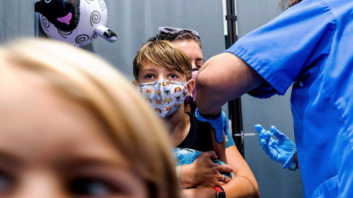 Finn Washburn, 9, receives an injection of the Pfizer-BioNTech COVID-19 vaccine in San Jose, Calif., on Wednesday, Nov. 3, 2021, as his sister, Piper Washburn, 6, waits her turn.