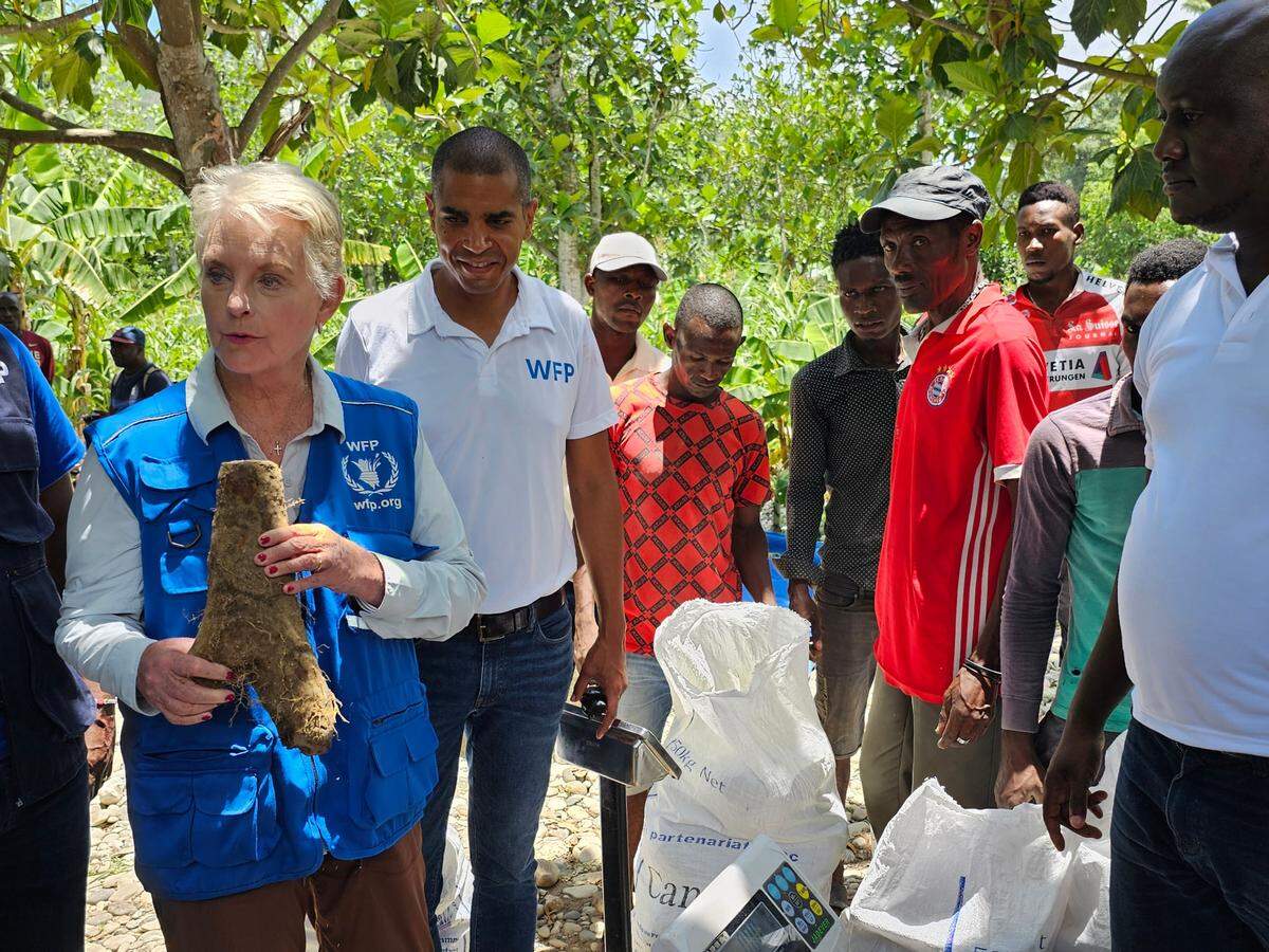 Cindy McCain, the new executive director of the U.N. World Food Program, holds up a yam while touring a farmers’ co-op in the Grand’Anse region of Haiti on Monday, June 19, 2023. The Réseaux des Organisations de Producteurs et Productrices de la Grand’Anse (ROPAGA) supplies locally produced crops to schools for WFP’s school feeding program.