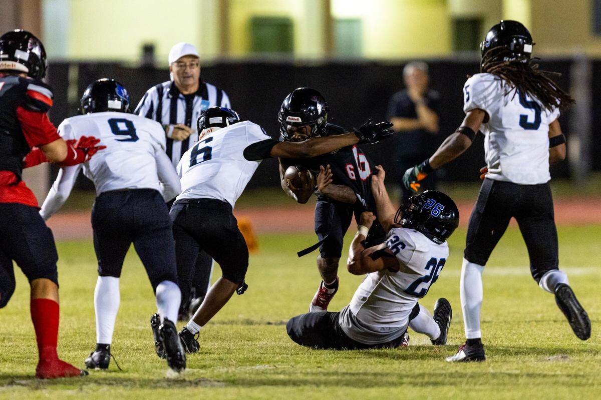 South Dade linebacker Sawyer Bartelt (26) sacks South Ridge quarterback Jayquan Reid (6) during the second half of a high school football game at South Ridge Stadium in Miami, Florida, on Friday, November 3, 2023.