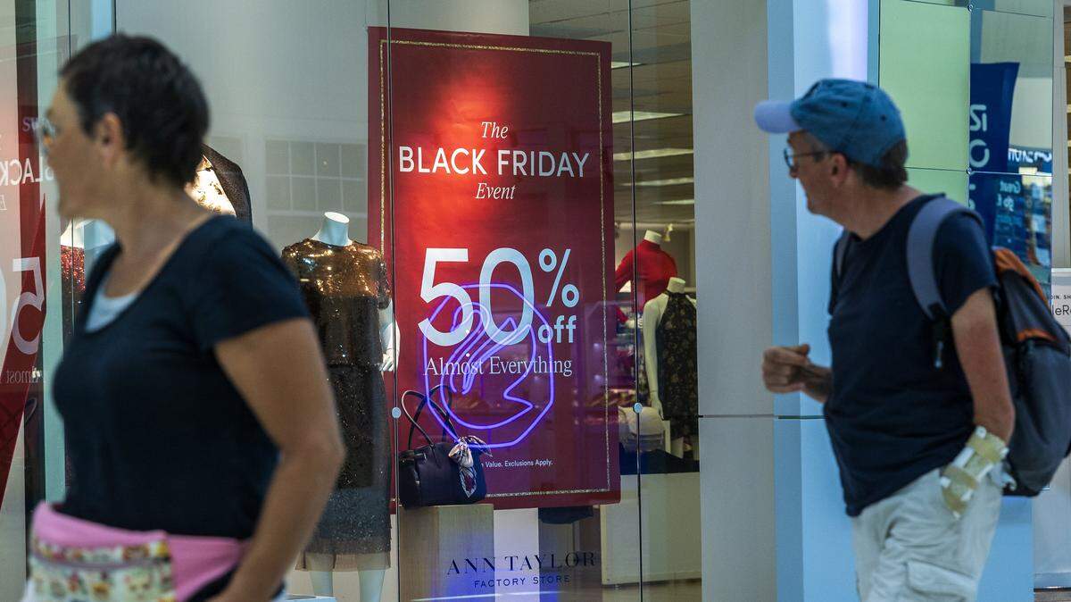 Shoppers walk by sales discount banners at the Ann Taylor’s store in the Dolphin Mall in Miami, ahead of Black Friday on Nov. 21, 2025.