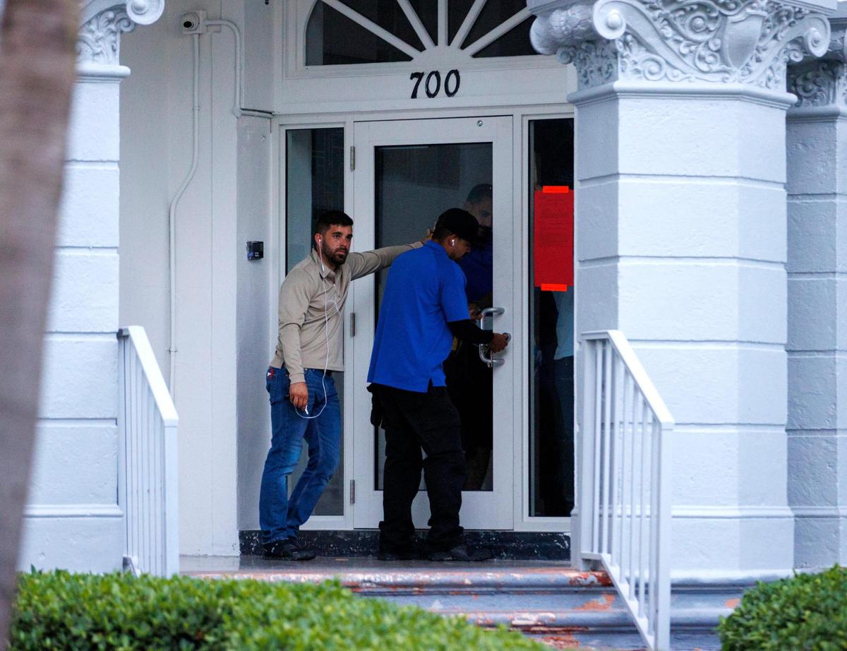 Employees of a four-story, 54-unit building located at 700 Euclid Ave. close the door after the building suffered a partial roof collapse and received an unsafe structure notice in Miami Beach, Florida, on Wednesday, June 15, 2022.