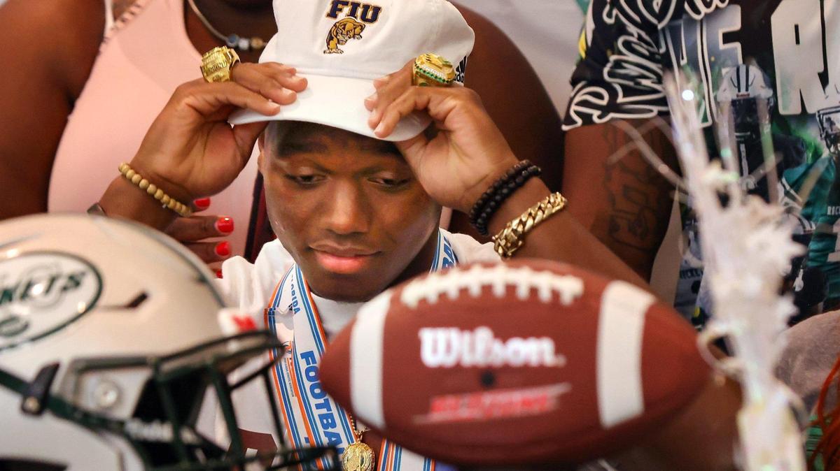 Quarterback Keyone Jenkins puts on his cap after deciding to sign with FIU. On Wednesday, December 21, 2022 Miami Central held its signing day for their senior players as the football players announced the colleges they plan to play for after graduation.
