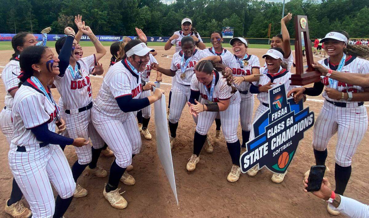 Doral Academy softball players celebrate after being awarded the FHSAA Class 6A state championship trophy on Saturday at Solider’s Creek Park in Longwood. Doral defeated defending state champions Pace 1-0.