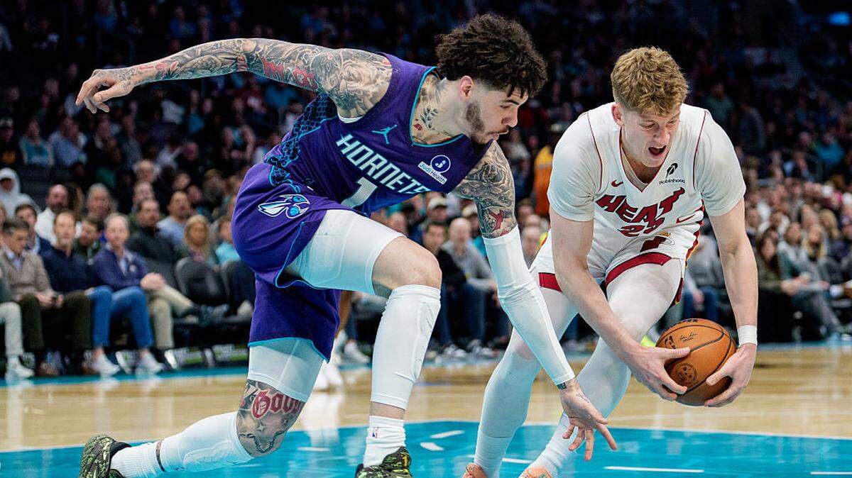 Kasparas Jakucionis #25 of the Miami Heat grabs the ball while guarded by LaMelo Ball #1 of the Charlotte Hornets in the first half during their game at Spectrum Center on March 17, 2026 in Charlotte.