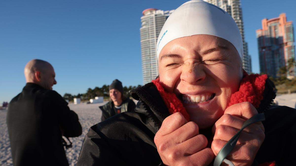 Fanny Kuhn, 32, right, visiting from Sweden, braced herself along with members of the Dolphins and Rainbows swimming clubs for an early morning swim in Miami Beach on Jan. 30, 2022, when temperatures hit the low 40s. A front is expected to bring low temperatures over the weekend in South Florida, forecasters say.
