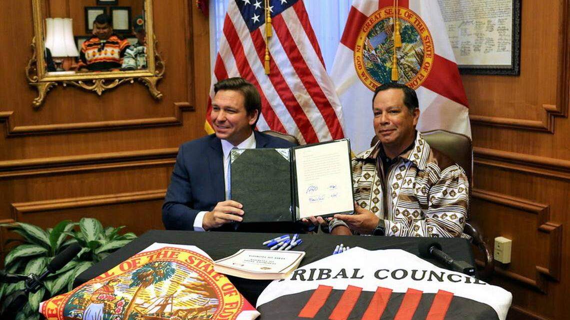 Gov. Ron DeSantis and Marcellus Osceola Jr., chairman of the Seminole Tribe, hold up the gaming compact that they signed in April 2021. EXECUTIVE OFFICE OF THE GOVERNOR