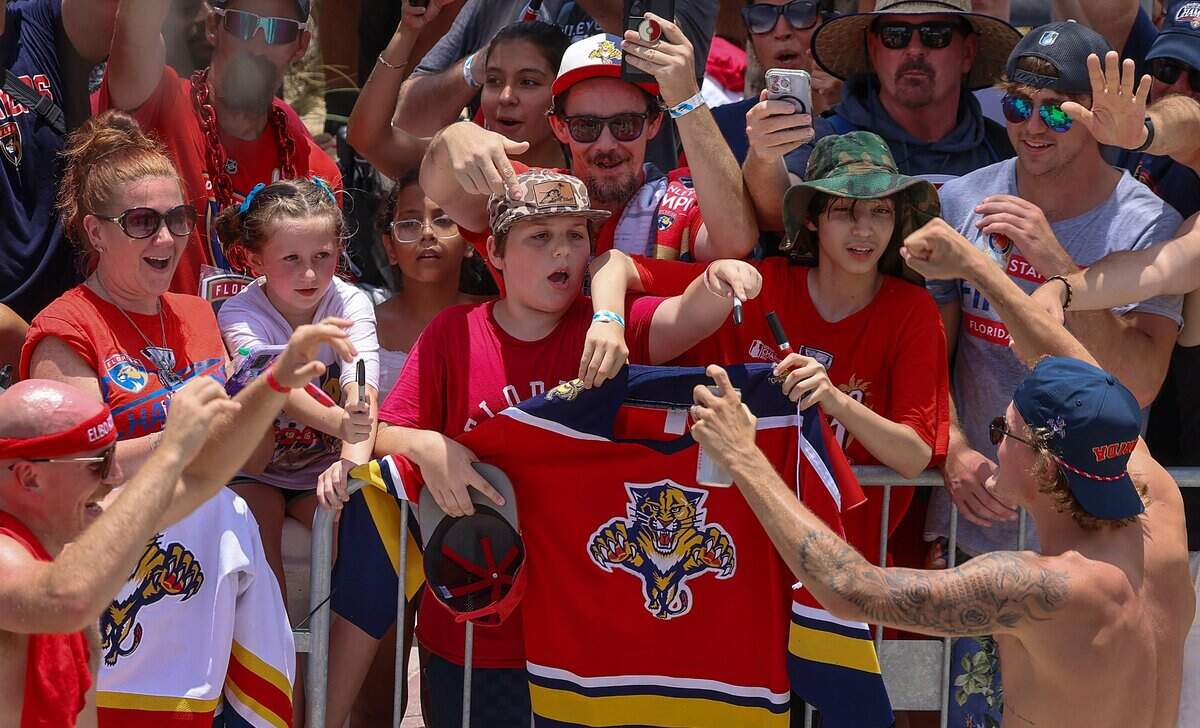 Panthers players Nate Schmidt (88) and Jesper Boqvist (70) greet fans and is showered with sparkling wine on A1A just north of the staging area for the Florida Panthers Stanley Cup championship celebration parade on Sunday, June 22, 2025 in Fort Lauderdale, Florida.