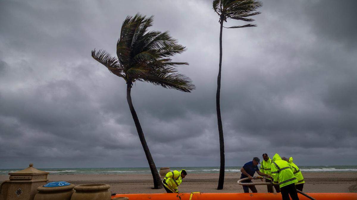 Trabajadores municipales de la Hollywood instalan un ‘Tiger Dam’ en la entrada de la calle Buchanan hacia Hollywood Beach. Debido a las inclemencias del tiempo, se han instalado ‘Tiger Dams’ en la playa alrededor del área del escenario en Johnson Stree. Los ‘Tiger Dams’ son barreras contra inundaciones reutilizables llenas de agua, con una vida útil de 17a 20 años. Vienen en longitudes de 50 pies o pueden personalizarse, en una imagen del 13 de diciembre de 2023. 