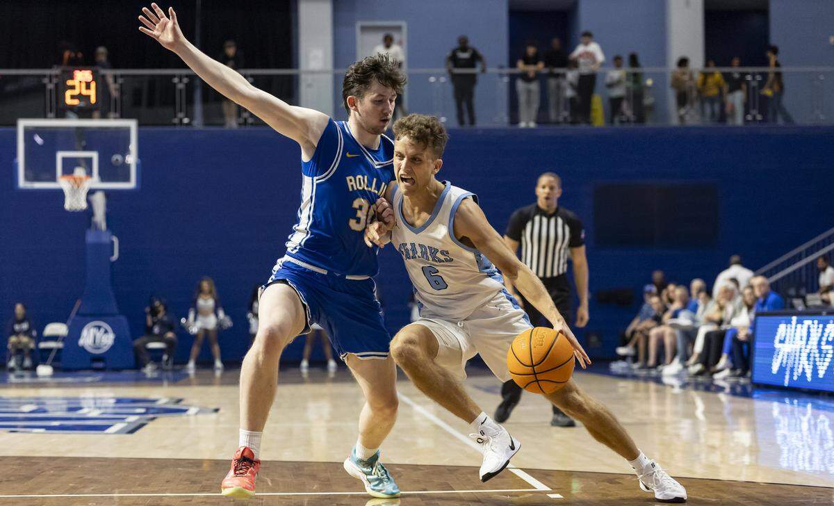 Nova Southeastern Sharks guard Ross Reeves (6) drives the ball as Rollins Tars guard Matus Malovec (30) defends in the first half of their Sunshine State Conference Championship quarterfinal basketball game at the Rick Case Arena on Tuesday, March 3, 2026, in Davie, Fla.