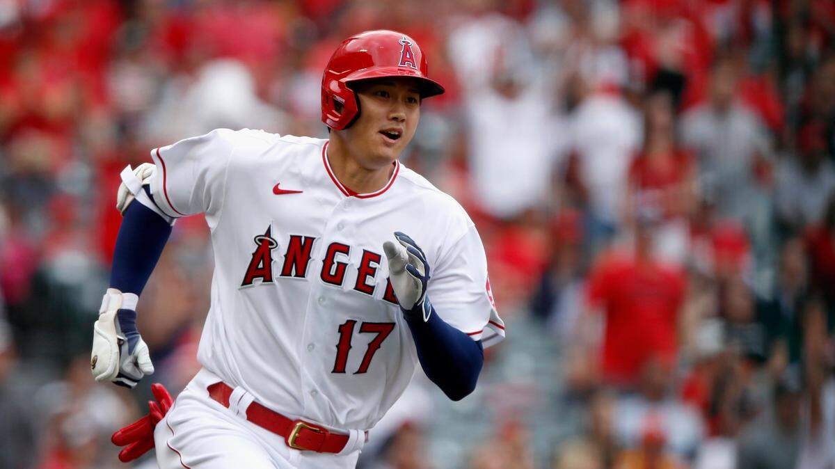 Los Angeles Angels’ Shohei Ohtani, right, runs out a ground rule double against the Houston Astros during the third inning of a baseball game in Anaheim, Calif., Sunday, April 10, 2022.