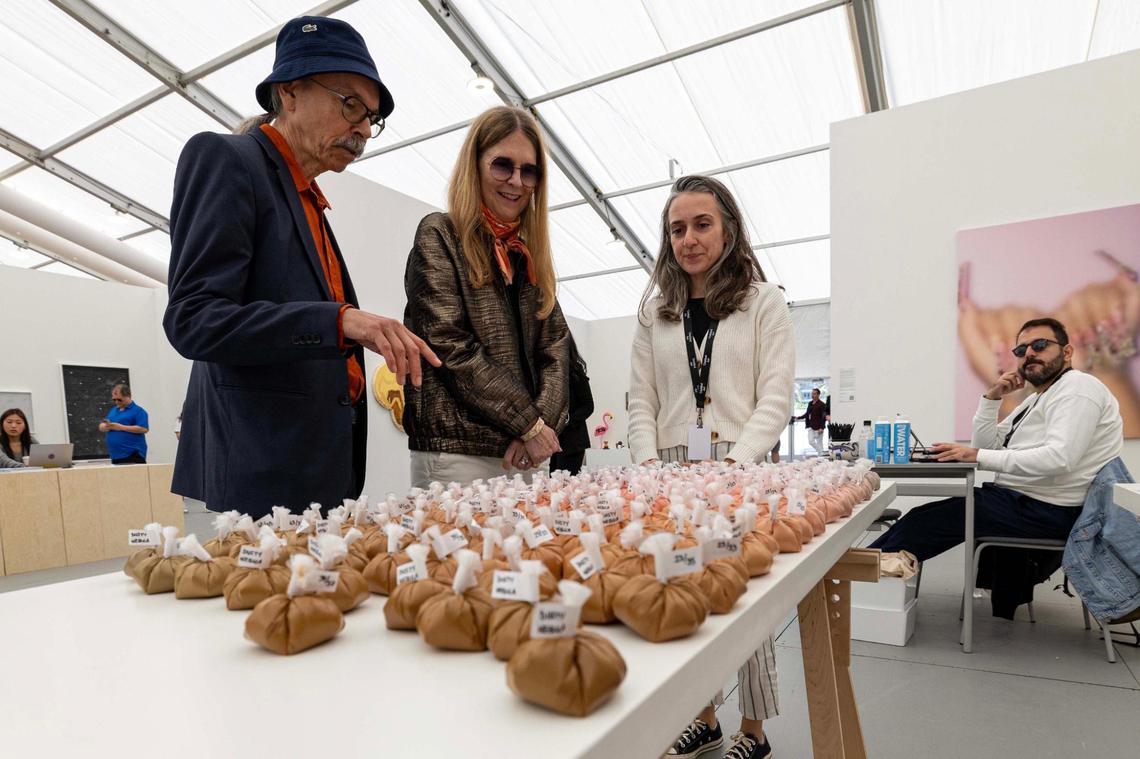 Guests look at an art exhibit at Untitled Art Fair for Art Miami Week on Tuesday, Dec. 3, 2024, in Miami Beach, Fla