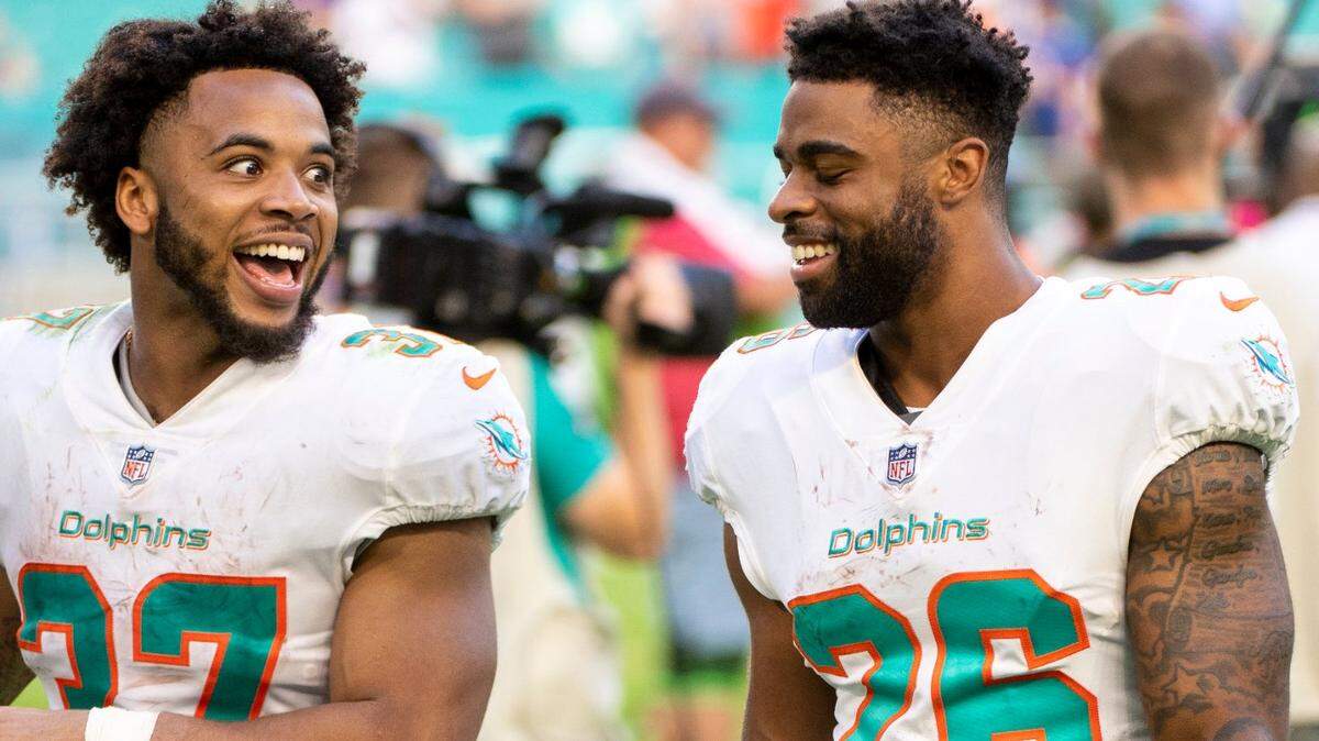 Miami Dolphins running back Myles Gaskin (37) and Miami Dolphins running back Salvon Ahmed (26) celebrate the Dolphins defeating the New York Giant after an NFL football game, Sunday, Dec. 5, 2021, in Miami Gardens, Fla. (AP Photo/Doug Murray)