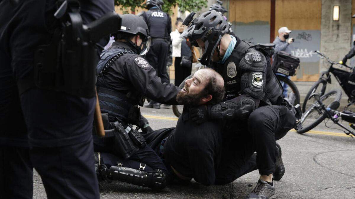 Seattle police arrest a demonstrator who was blocking the intersection after police cleared the Capitol Hill Occupied Protest and retook the department’s East Precinct .