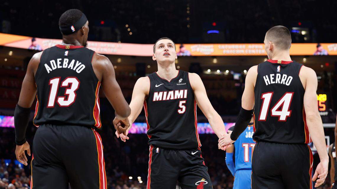 Miami Heat forward Nikola Jovic (5) celebrates with teammates center Bam Adebayo (13) and guard Tyler Herro (14) after a play against the Oklahoma City Thunder during the second quarter at Paycom Center.