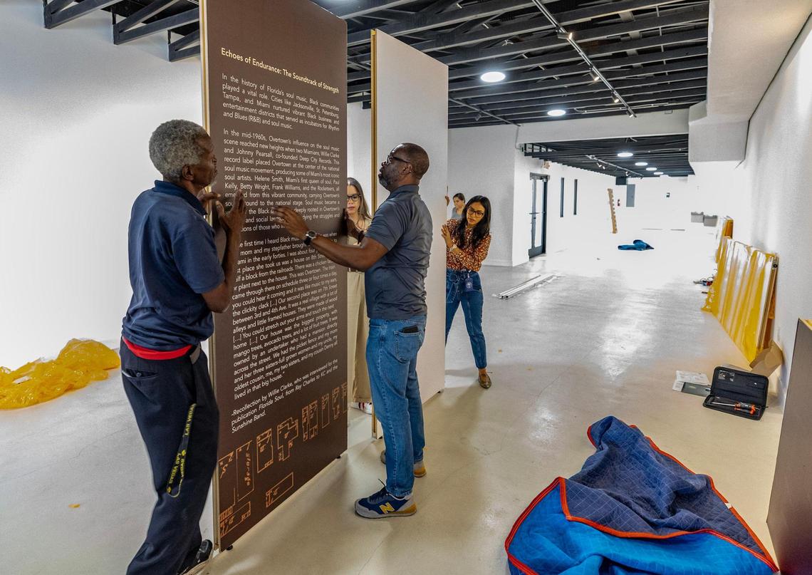 Jesille Peters and Fred McNair work with special projects coordinator, Alba De La Paz to set up the Sepia Vernacular exhibit at the former law office of Judge Lawson E. Thomas. The piece will be a part of an exhibit during Soul Basel in Overtown.