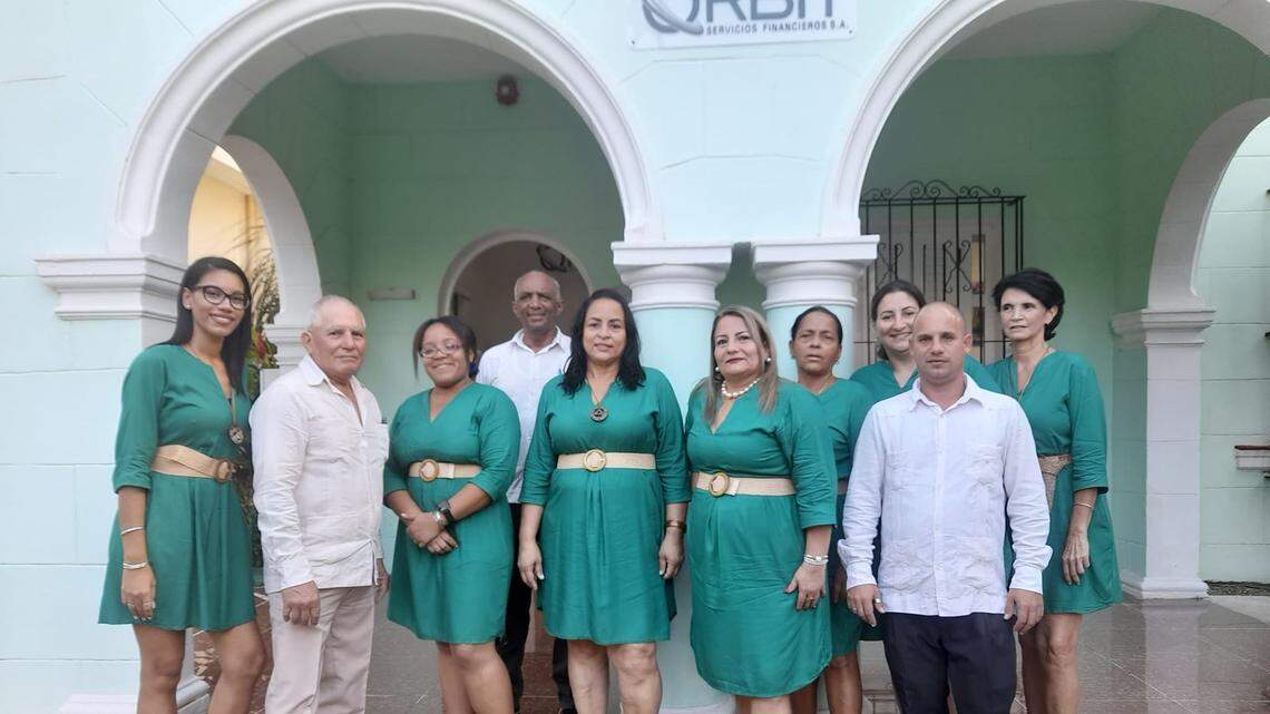 Wearing a pearl necklace, Diana Rosa Rodríguez Pérez, director of Orbit SA, poses with the company staff in front of its headquarters in Miramar, Havana. Previously, she was a high-ranking official in two firms controlled by Cuba’s military.