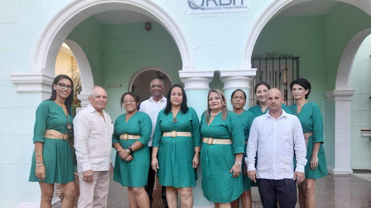 Wearing a pearl necklace, Diana Rosa Rodríguez Pérez, director of Orbit SA, poses with the company staff in front of its headquarters in Miramar, Havana. Previously, she was a high-ranking official in two firms controlled by Cuba’s military.