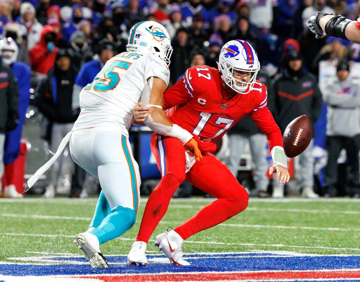 Miami Dolphins linebacker Jaelan Phillips (15) strip-sack Buffalo Bills quarterback Josh Allen (17) during fourth quarter of an NFL football game at Highmark Stadium on Saturday, December 17, 2022 in Orchard Park, New York.