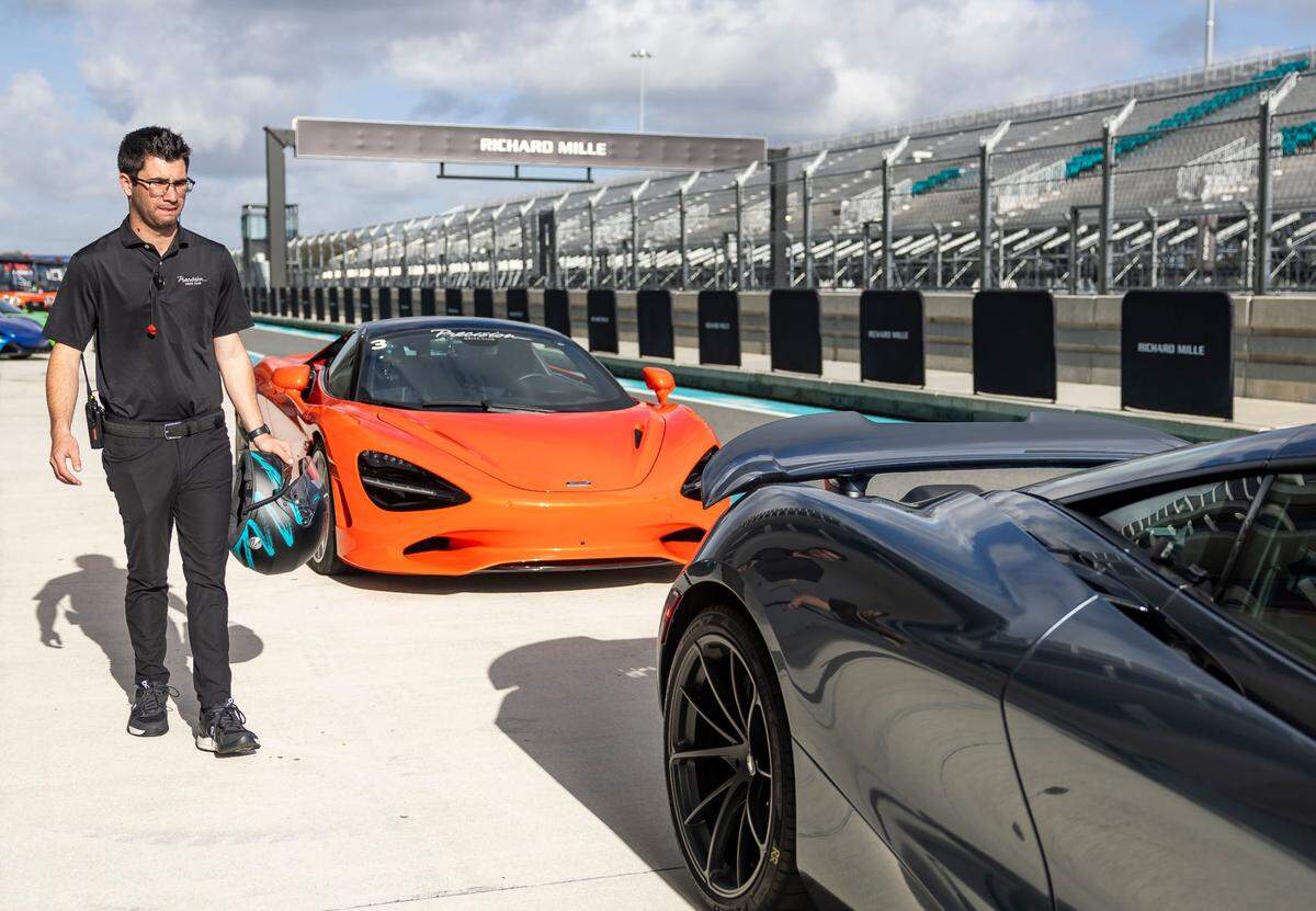 Jenson Altzman, a driver coach with the Precision Drive Club, looks at parked cars during the F1 Miami GP Media Day at the Miami International Autodrome inside the Hard Rock Stadium on Thursday, Feb. 13, 2025, in Miami Gardens, Fla.