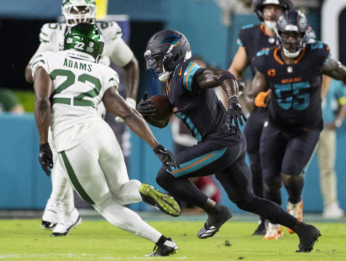 Miami Dolphins wide receiver Tyreek Hill (10) runs with the ball as New York Jets safety Tony Adams (22) tries to tackle him in the first half of their NFL game at Hard Rock Stadium on Monday, Sept. 29, 2025, in Miami Gardens, Fla.