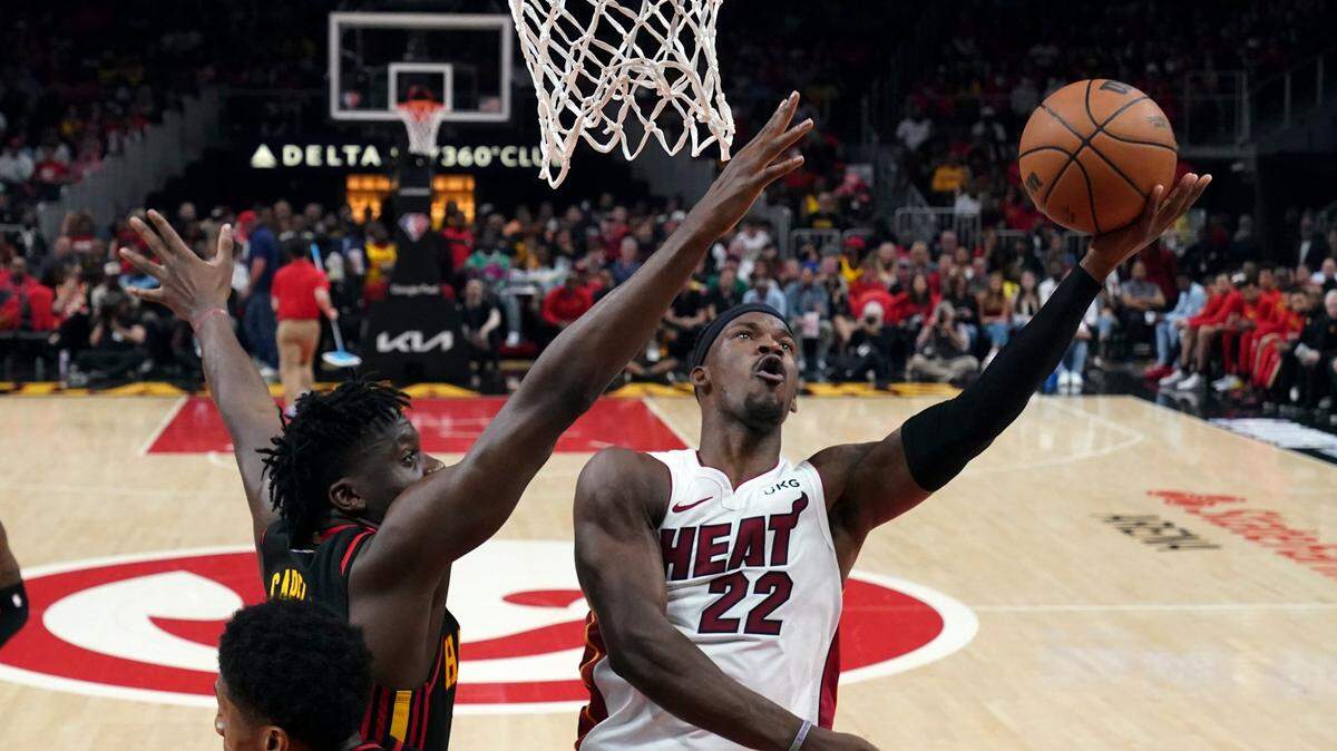 Miami Heat forward Jimmy Butler (22) shoots as Atlanta Hawks center Clint Capela (15) defends in the first half of an NBA playoff basketball game Sunday, April 24, 2022, in Atlanta.