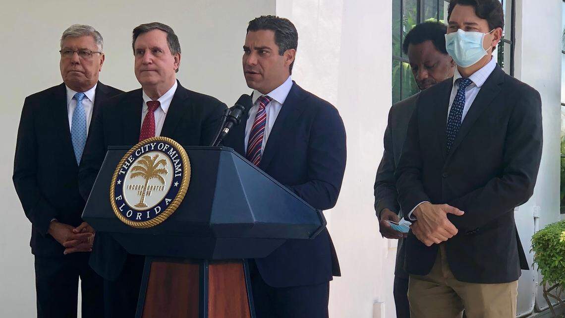 From left to right: Miami Commissioners Manolo Reyes, Joe Carollo, Jeffrey Watson and Ken Russell stand with Mayor Francis Suarez (center podium) during a press conference to urge President Joe Biden to take stronger action against Cuba.