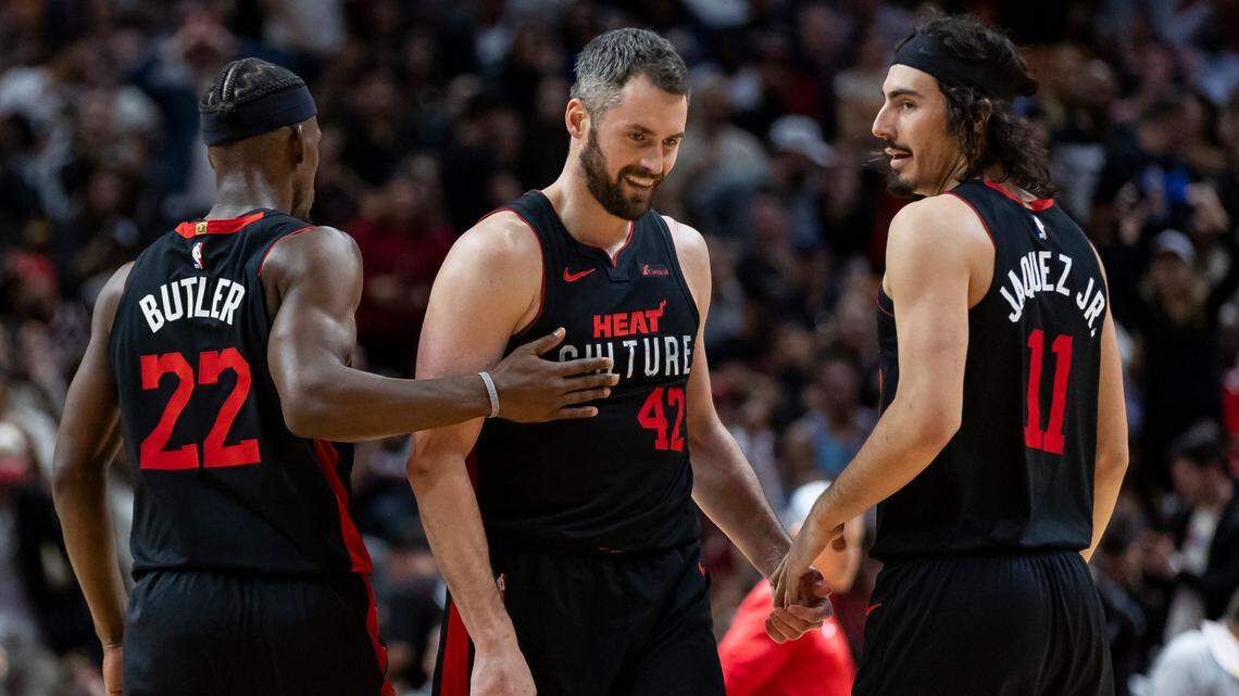 Miami Heat forward Jimmy Butler (22) celebrates with forward Kevin Love (42) and guard Jaime Jaquez Jr. (11) after scoring against the Chicago Bulls in the third quarter of an NBA game at Kaseya Center on Dec. 16, 2023, in Miami.