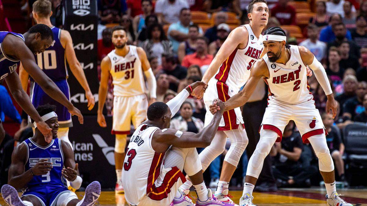Duncan Robinson (55) y Gabe Vincent (2) ayudan a levantarse a Bam Adebayo (13), en el juego contra los Kings de Sacramento, el 2 de noviembre de 2022 en Miami.