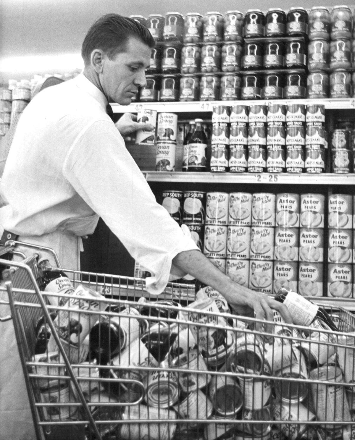 In 1959, at Kwik Chek, a foreunner to Winn-Dixie, a clerk stocks cans of cranberries.