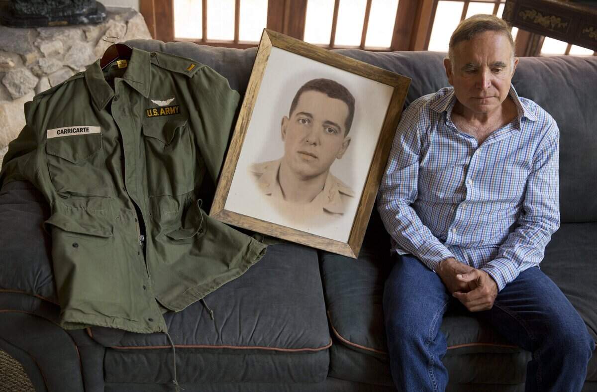 Mike Carricarte, older brother of Louis Carricarte, a Vietnam soldier killed at war in 1963, with his brothers army jacket and portrait at Mike's home in Miami on Aug. 20, 2013.