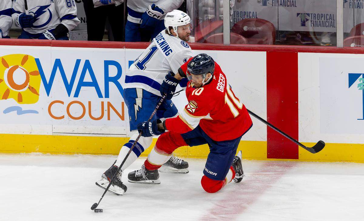 Florida Panthers left winger A.J. Greer (10) and Tampa Bay Lightning center Luke Glendening (11) compete for the puck during the first period of an NHL game at Amerant Bank Arena, Monday, Dec. 23, 2024, in Sunrise, Florida.
