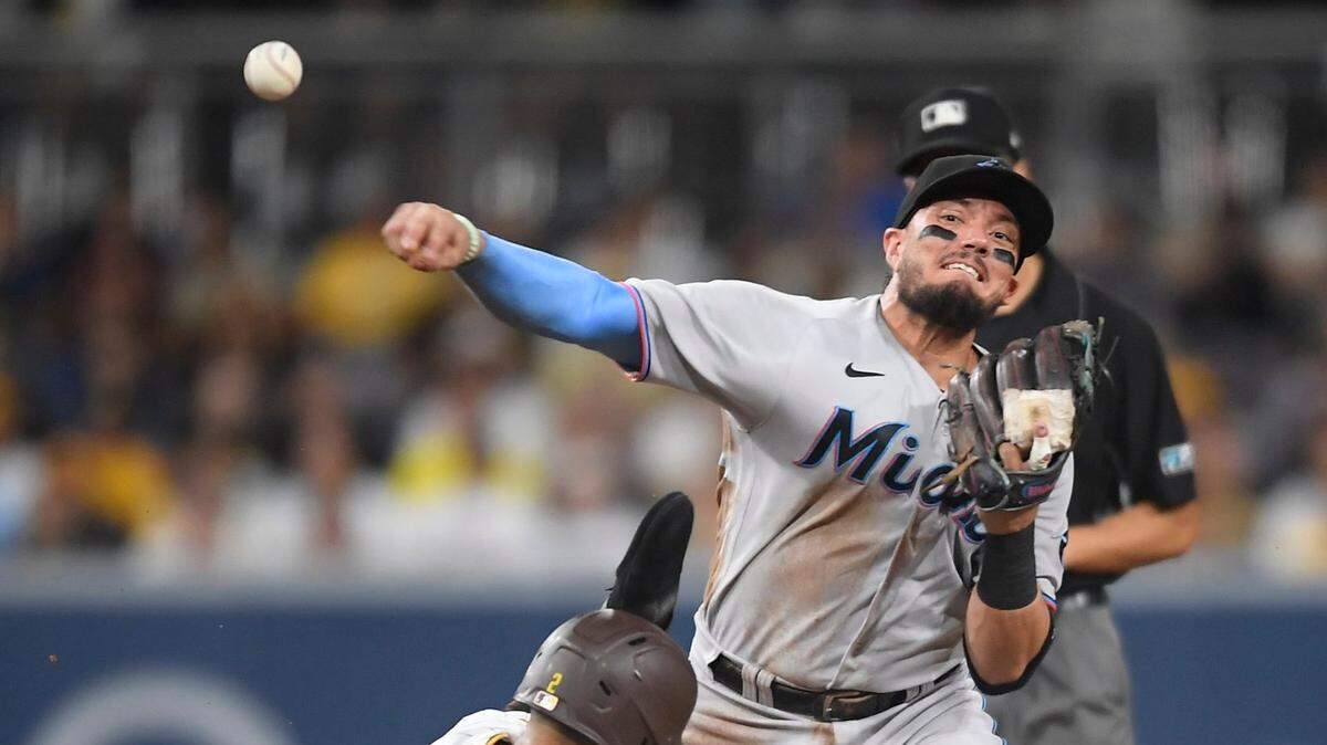 Miguel Rojas #19 of the Miami Marlins throws over Trent Grisham #2 of the San Diego Padres as he attempts to turn a double play during the second inning of a baseball game at Petco Park on August 10, 2021 in San Diego, California.