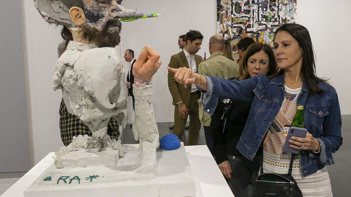 Iris Singer, from Arizona, points at “Spirit Transfer” by David Altmejd during Art Basel at the Miami Beach Convention Center on Dec. 4, 2019.