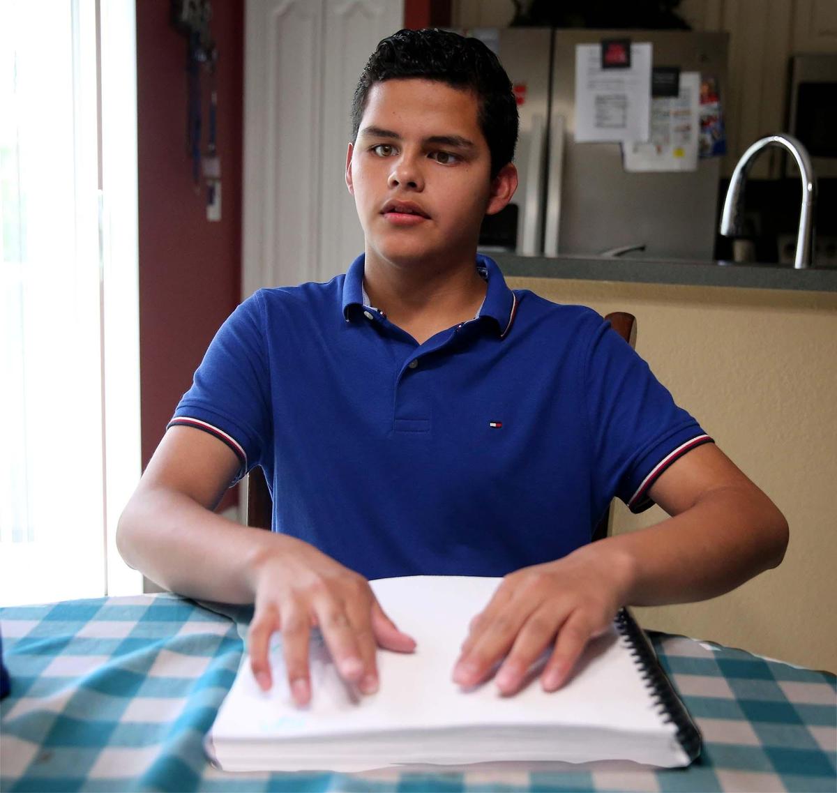 Silvio Plata 15, reads from a Braille book, June 12, 2019. The Miami high school sophomore will compete in the 2019 Braille Challenge National Finals in California.