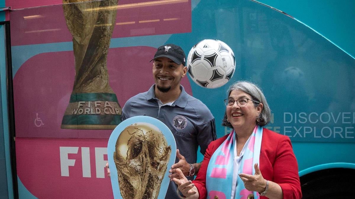 Miami, Florida - May 18, 2023 - Miami Dade County Mayor, Daniella Levine Cava, right, and Inter Miami’s Gregore pose for photos in front of the 2026 FIFA World Cup / Miami logo