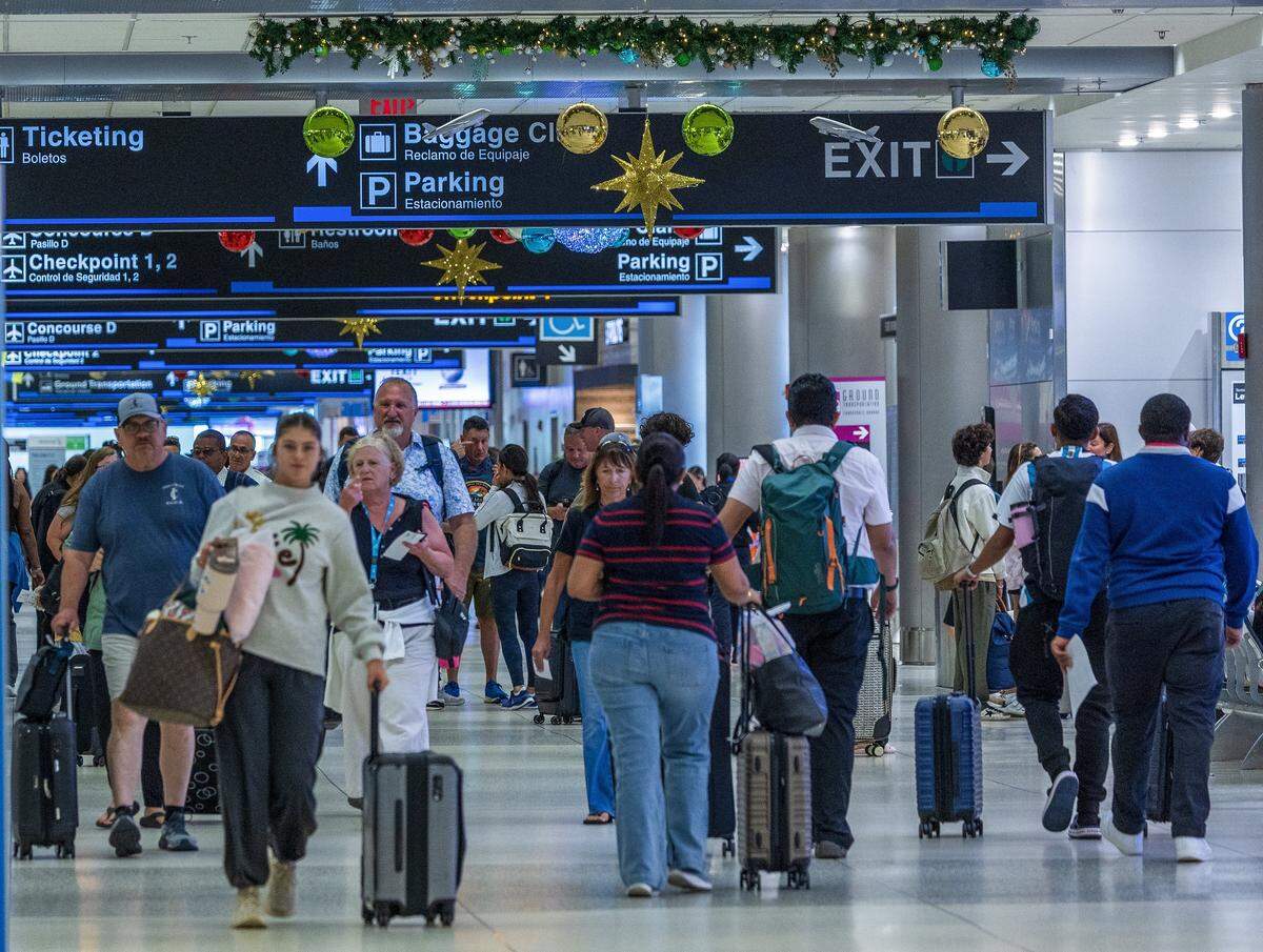 Passengers walked down the hallway in Concourse D, at Miami International Airport ahead of the Holidays in Miami, on Friday, November 21, 2025.