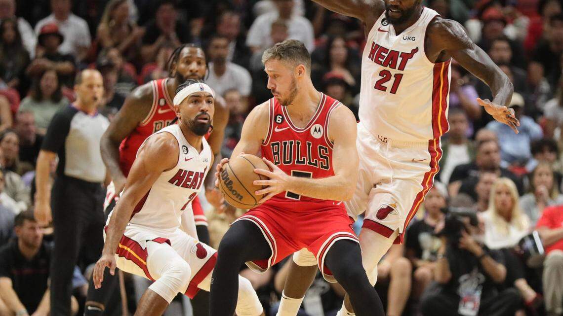 Chicago Bulls guard Goran Dragic (7) is defended by Miami Heat guard Gabe Vincent (2) and Miami Heat center Dewayne Dedmon (21) in the second half at FTX Arena on Wednesday, October 19, 2022.