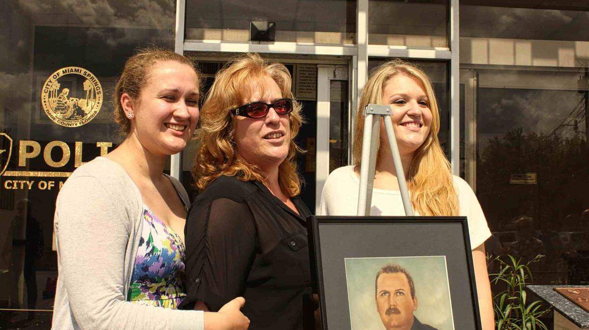 Cecilia Stafford, widow of former Miami Springs Police Officer Charles B. Stafford, with daughters, Natalie and Katherine, at a 2011 memorial.