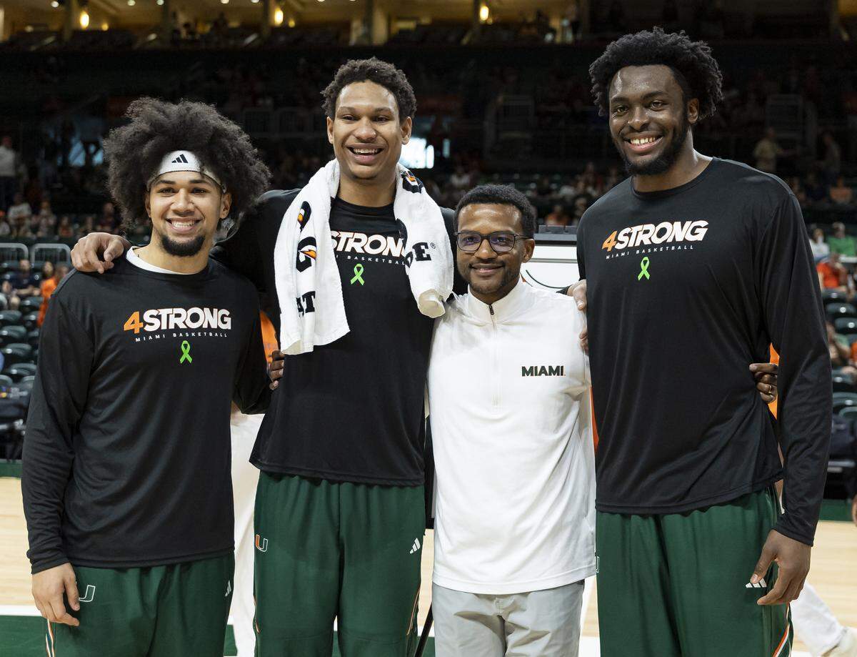 Miami Hurricanes guard Tre Donaldson (3), forward Malik Reneau (5), head coach Jai Lucas and center Ernest Udeh Jr. (8) gather for a group photo during a pre-game ceremony for Senior Day before their team's NCAA basketball game at the Watsco Center on Saturday, March 7, 2026, in Coral Gables, Fla.
