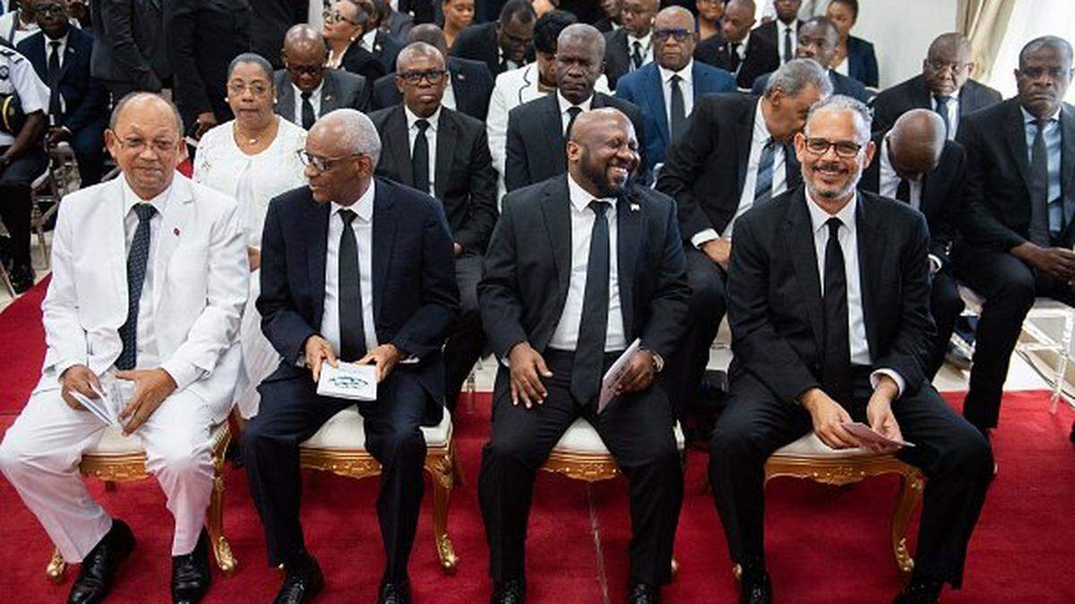 Haiti's Prime Minister Alix Didier Fils-AimÃ© (R, front row) sits with Transitional Presidential Council members Leslie Voltaire (L), Edgard Leblanc Fils (2nd L), and Smith Augustin (3L) as they attend a ceremony to mark 4 years since the assassination of former president Jovel Moise in Port-au-Prince, Haiti, on July 7, 2025. Moises was killed by armed gunmen at his home in a Port-au-Prince suburb on July 7, 2021. (Photo by Clarens SIFFROY / AFP) (Photo by CLARENS SIFFROY/AFP via Getty Images)