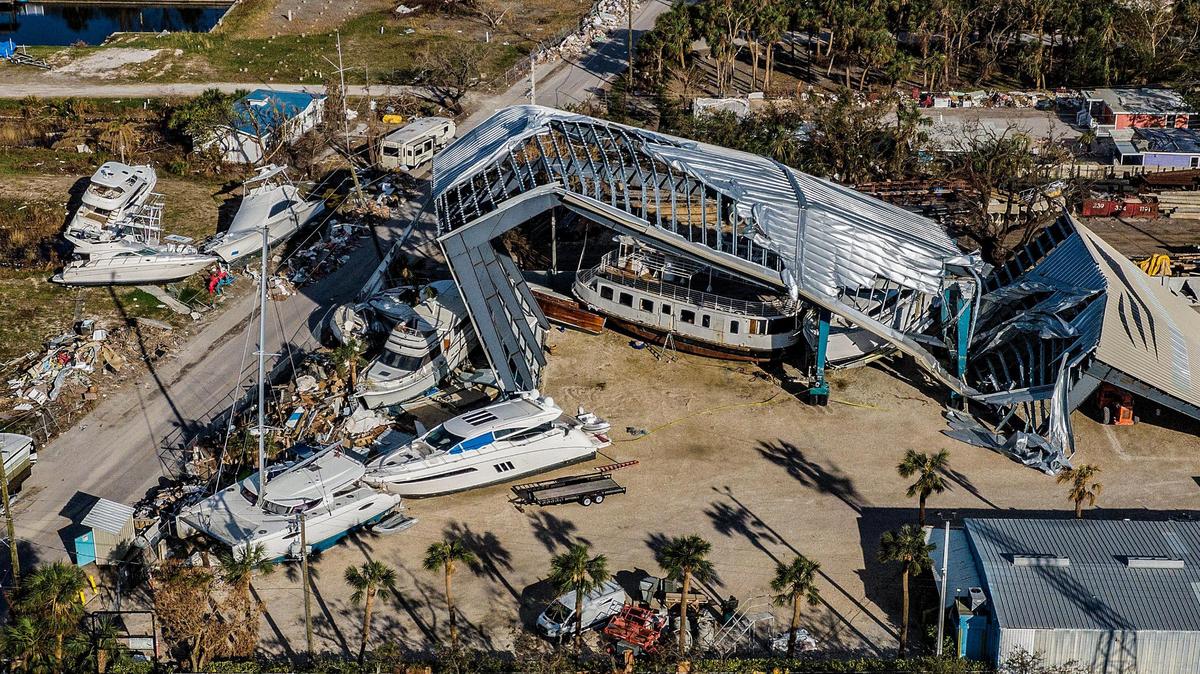 A large boats sit wrecked by a damaged hangar on San Carlos Island in Fort Myers Beach on Oct. 26 after Hurricane Ian.