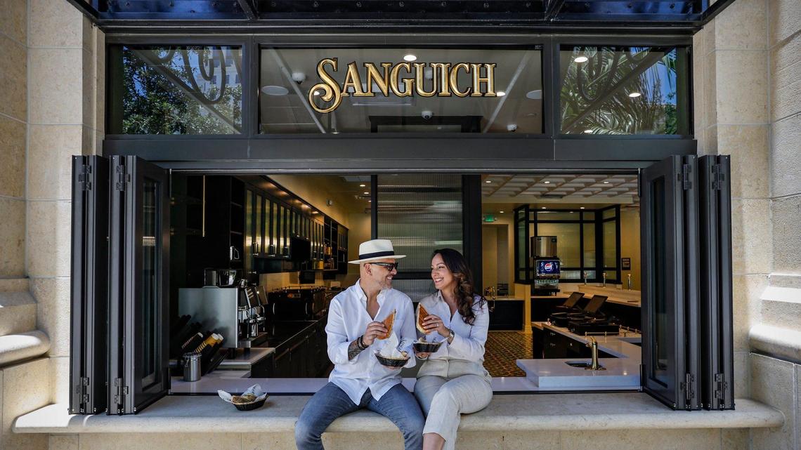 Husband-and-wife team Daniel Figueredo and Rosa Romero, owners of Sanguich, sit on the ledge of the ventanita of their new restaurant in Coral Gables.