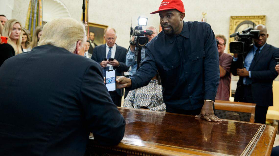 Rapper Kanye West shows President Donald Trump a photograph of a hydrogen plane during a meeting in the Oval Office of the White House, Thursday, Oct. 11, 2018, in Washington. (AP Photo/Evan Vucci)
