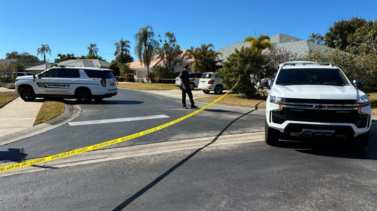 Sarasota Sheriff’s Office deputies stand outside a house blocked off with crime scene tape in the Amberlea neighborhood Tuesday, Feb. 10, 2026. One person was found shot dead in the front yard, and four others were found dead inside the house, the sheriff’s office said.
