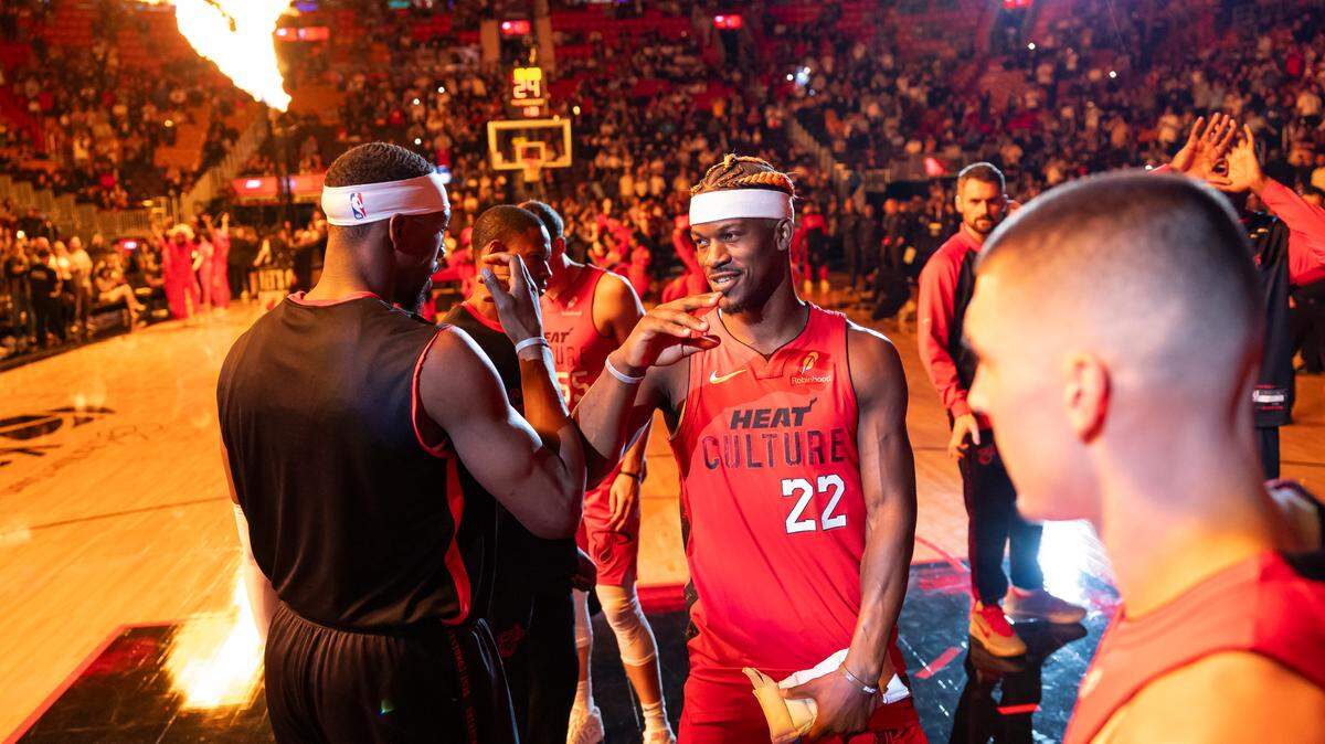 Miami Heat forward Jimmy Butler (22) and center Bam Adebayo (13) react before the start of their NBA game against the Toronto Raptors at Kaseya Center on Dec. 12, 2024, in Miami.