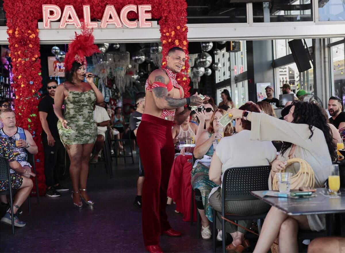 Performer “Oscar G,” center, collects his tips from adoring fans after his set at the Palace. The Palace, an LGBTQ + friendly bar and restaurant, is known for its high-energy weekend drag brunches, where performers entertain guests with choreographed dances, lip-syncs and audience interaction. The scene was photographed on Sunday, June 28, 2026, in Miami Beach, Fla.