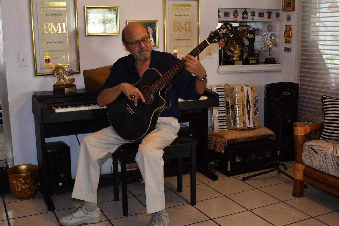 Luis Alva plays his guitar at home